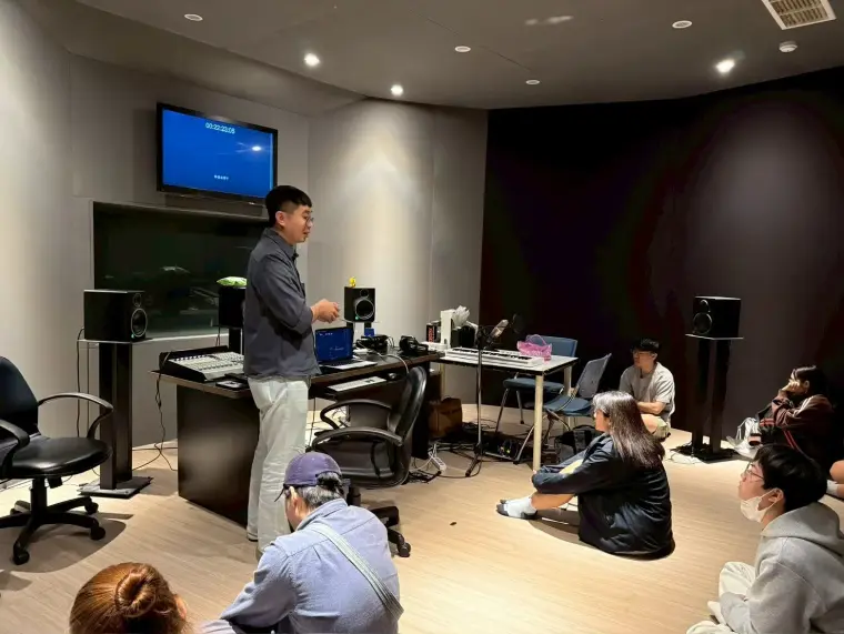 教師在 50208 環繞錄音室向學生講解 AI 配樂與音訊工具
