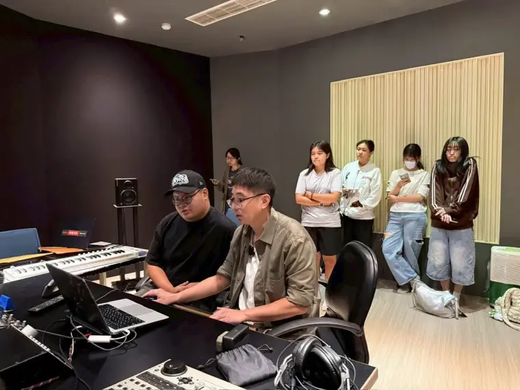 學生在控制台前操作混音設備