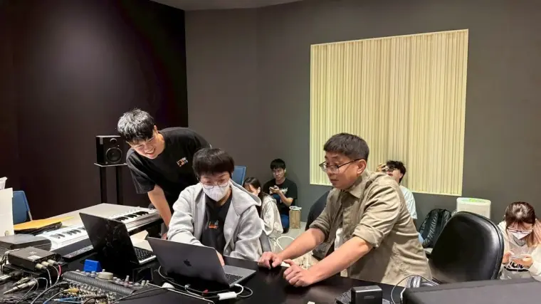 學生以筆電與錄音室設備進行作品整理